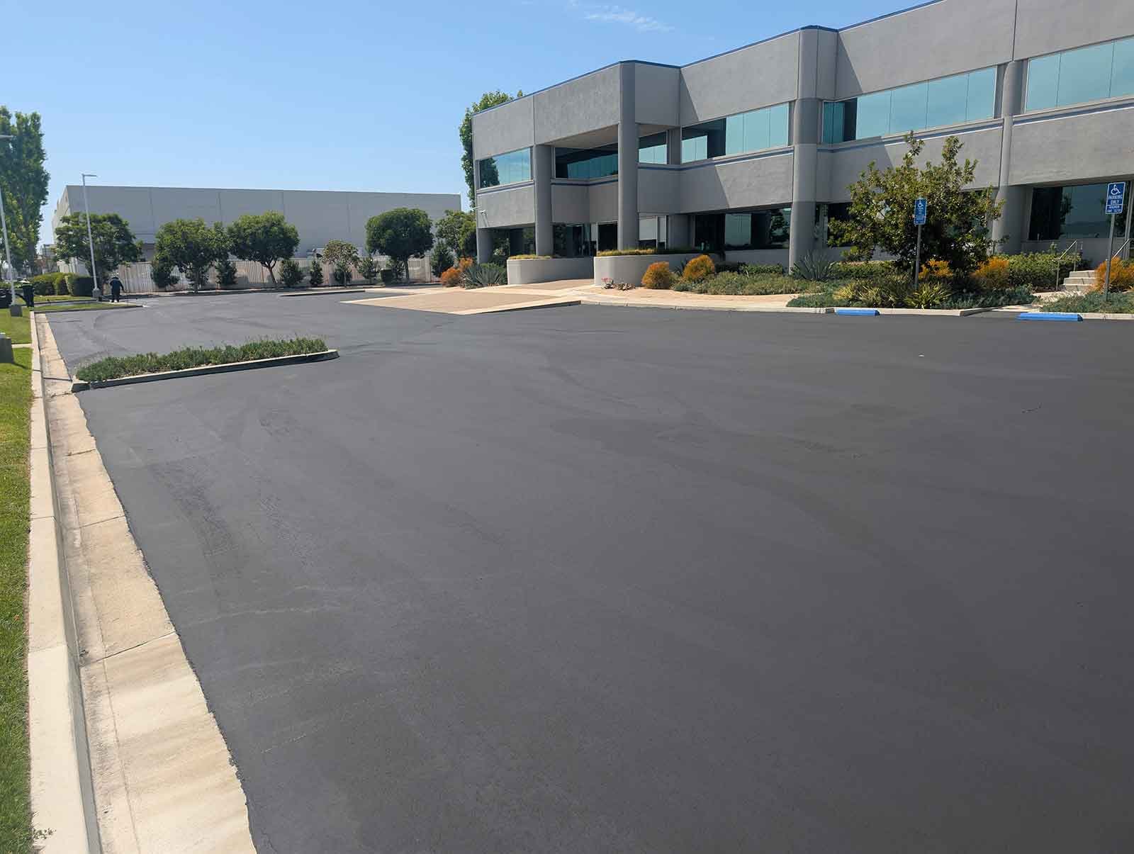 Image of a freshly sealed parking lot outside of a building